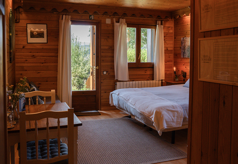 Cozy wooden guest room with double bed and natural light at Minds and Mountains ecolodge
