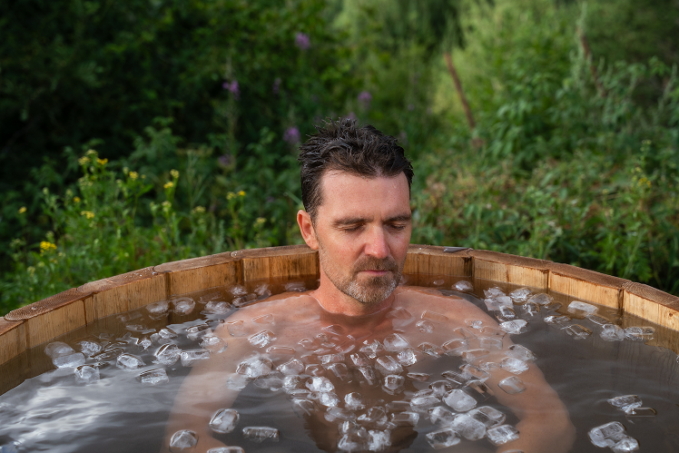 Ice Bathing Mikkem practicing ice bathing in a wooden tub during the retreat